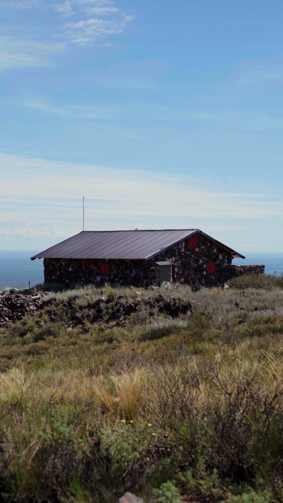 The Swiss Refuge: stone cabin with red shutters on the mountain ridge at La Rivera